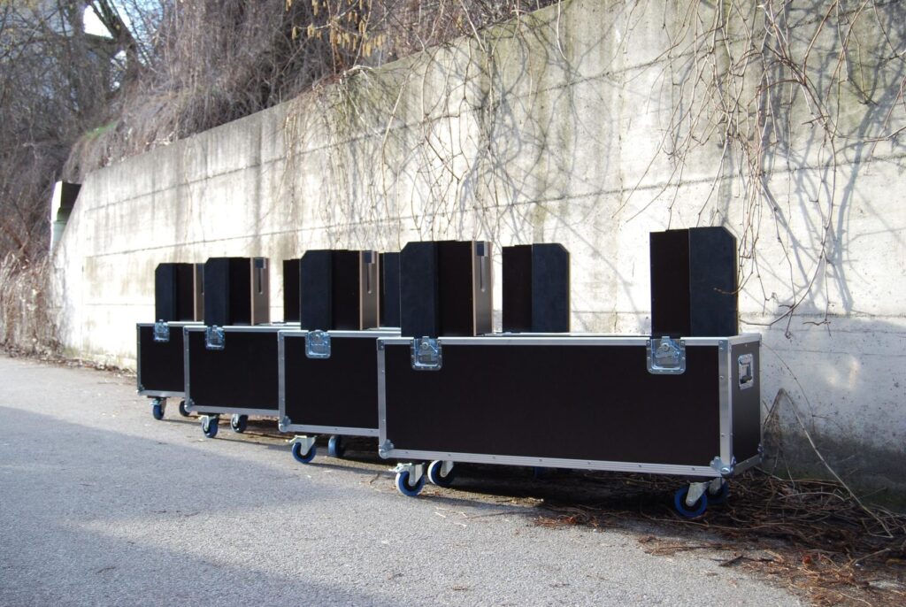 Reihe fahrbarer Flightcases auf Rollen vor einer Betonwand – Transportkoffer nach Maß von LIHA, Steyregg