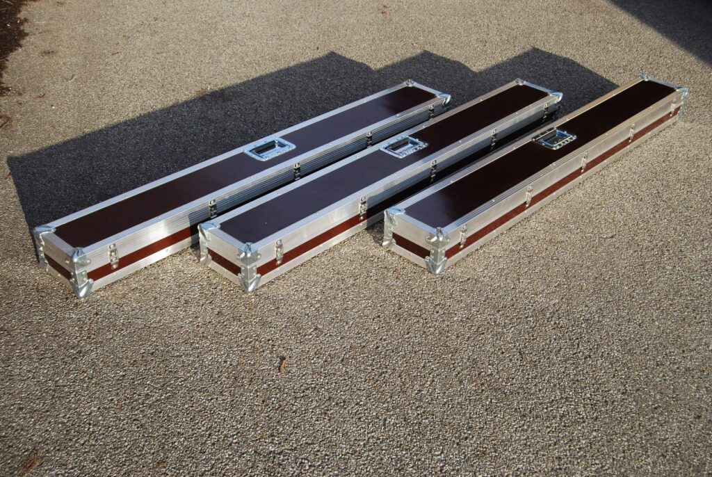 Drei lange, schmale Flightcases mit Aluprofil-Kanten und Griffen – Transportkoffer nach Maß von LIHA